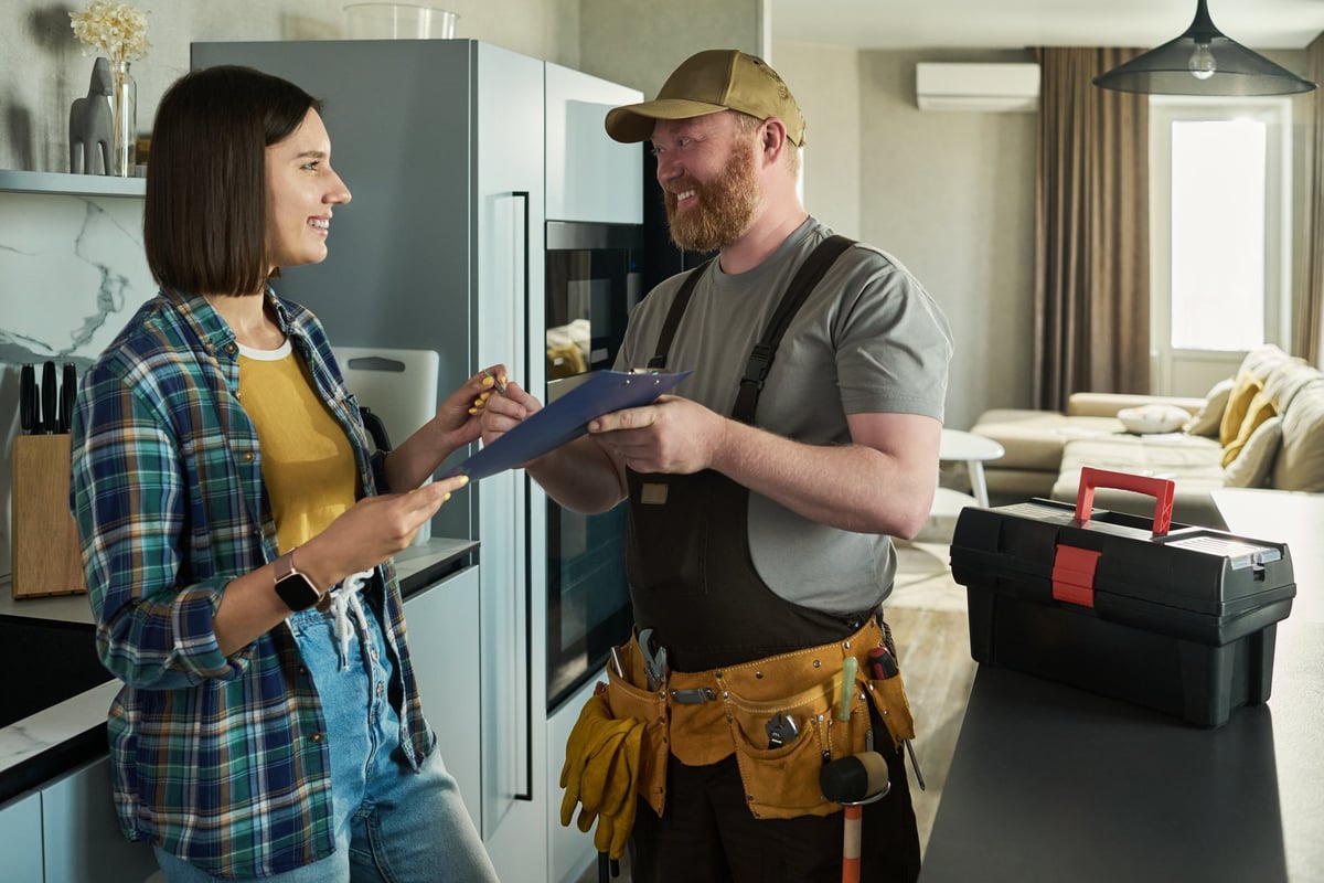 HVAC technician reviewing documentation with a homeowner in a professional setting, building trust through clear communication