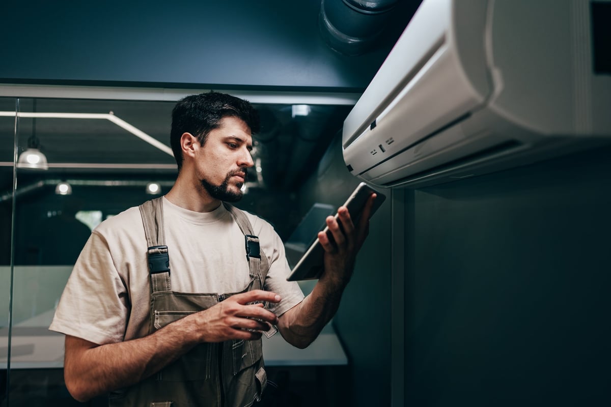 HVAC technician using a tablet to review and document findings during a service call